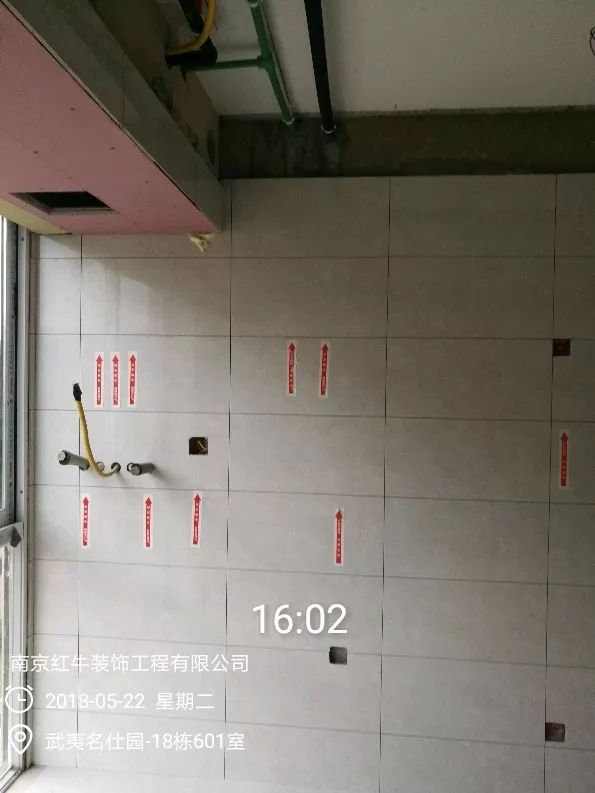 南京武夷名仕園124平米簡(jiǎn)美風(fēng)格裝修  享受家?guī)?lái)的溫度30五月份_墻磚鋪貼完成后，紅牛裝飾的工人會(huì)用專用護(hù)角條對(duì)瓷磚角保護(hù)，用標(biāo)貼標(biāo)出水管、線管走向示意。